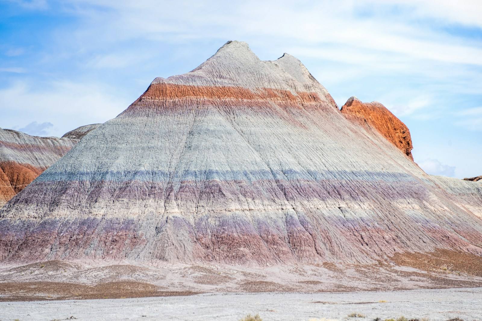 A hill in the Blue Mesa section of the Petrified Forest National Park, Arizona, showcasing vibrant and layered tones of purple, blue and red