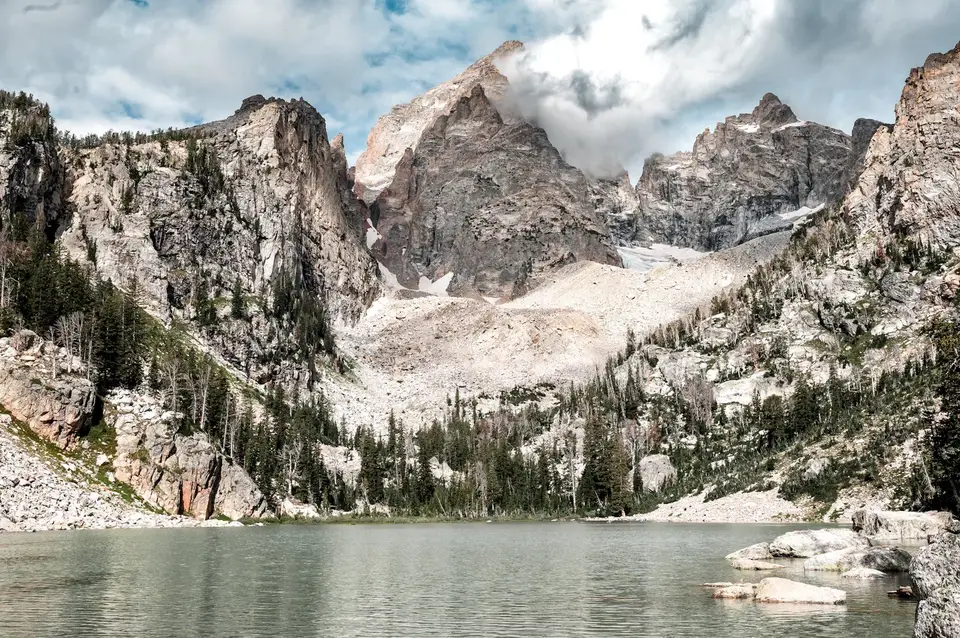 Pale blue lake below the Grand Teton and surrounding cliffs