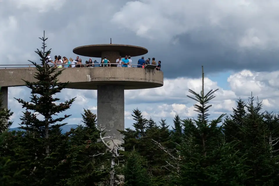 Visitors on the round observation tower at Kuwohi above a forest of spruce and fir