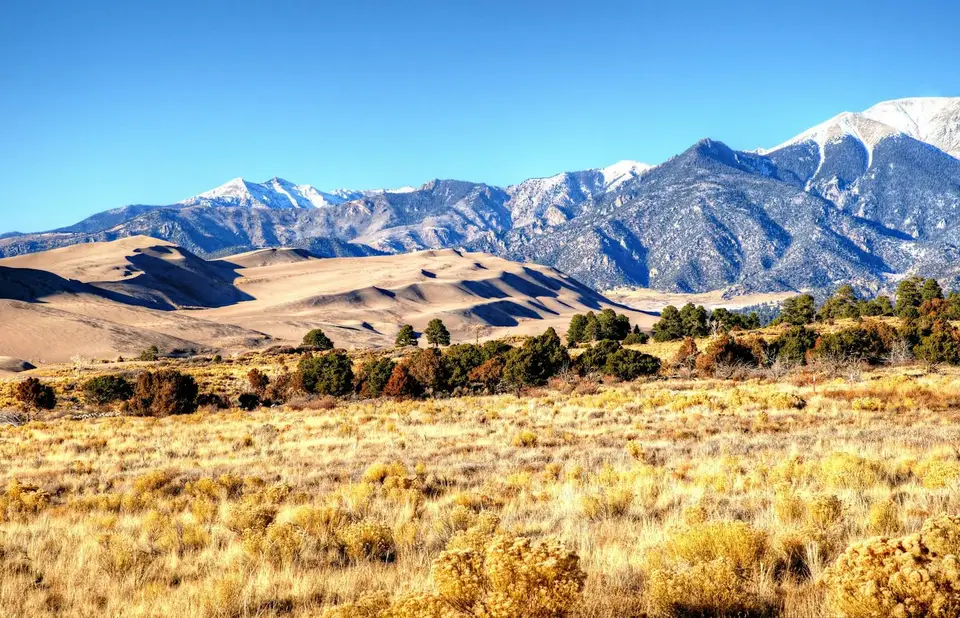 Great Sand Dunes Afternoon Mountains and Shadows. At Colorado's Great Sand Dunes National Park blue skies and mountains form a backdrop to d